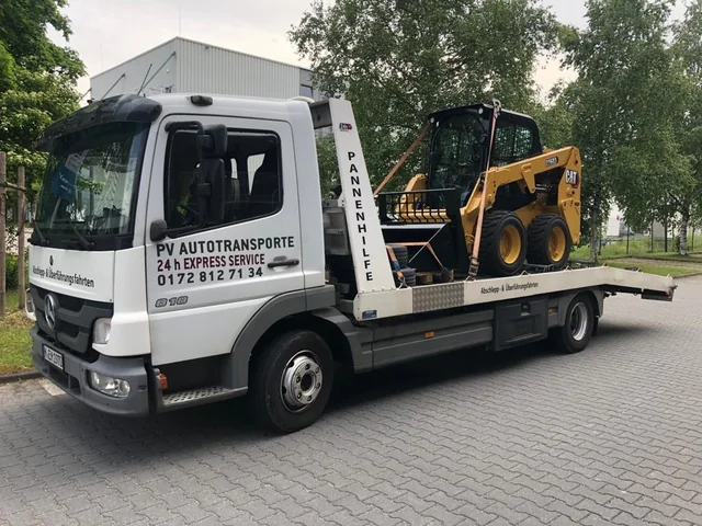 Gelbe CAT-Baumaschine auf einem PV Transportfahrzeug