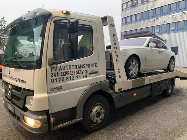 Weißer Rolls-Royce Ghost auf einem Mercedes Atego Transportfahrzeug