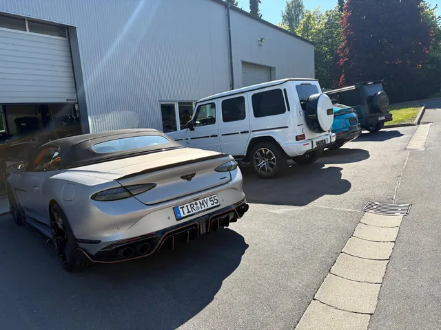 Grauer Rolls-Royce neben einer weißen Mercedes G-Klasse