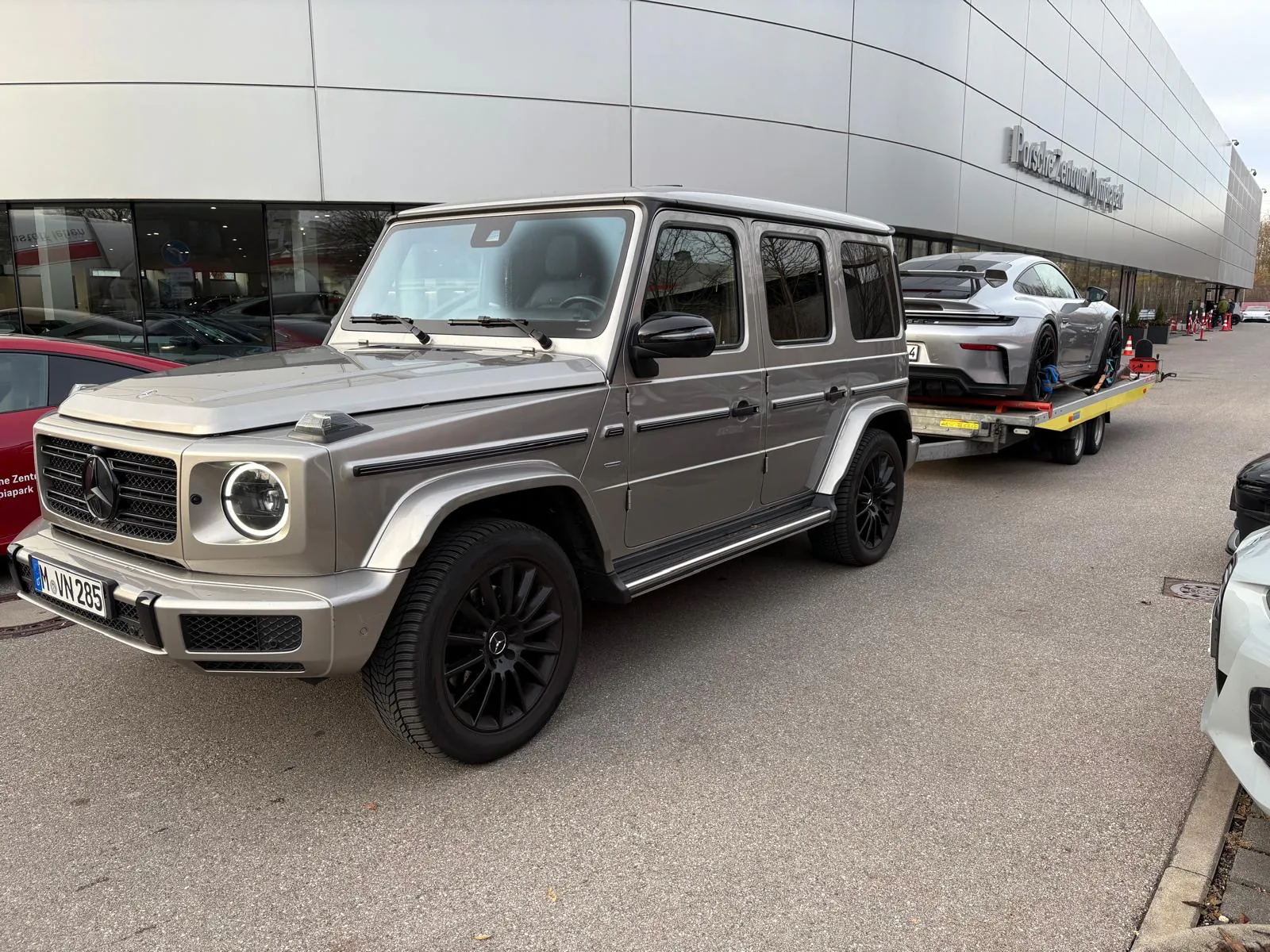 Mercedes G-Klasse mit Porsche 911 GT3 auf einem Fahrzeuganhänger