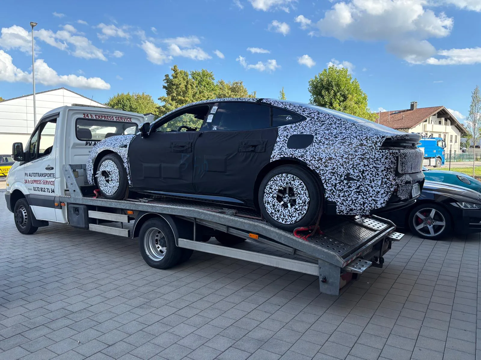 Getarnter Fahrzeugprototyp vollständig gesichert auf einem PV Transportfahrzeug