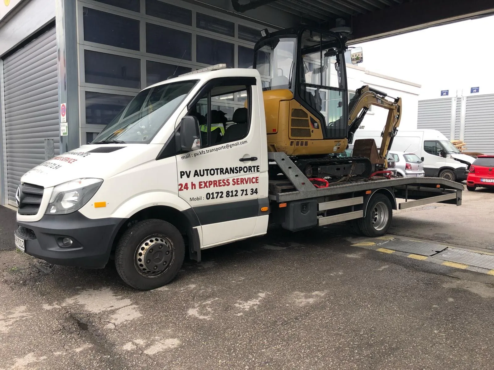 Kompaktbagger auf einem PV Transportfahrzeug