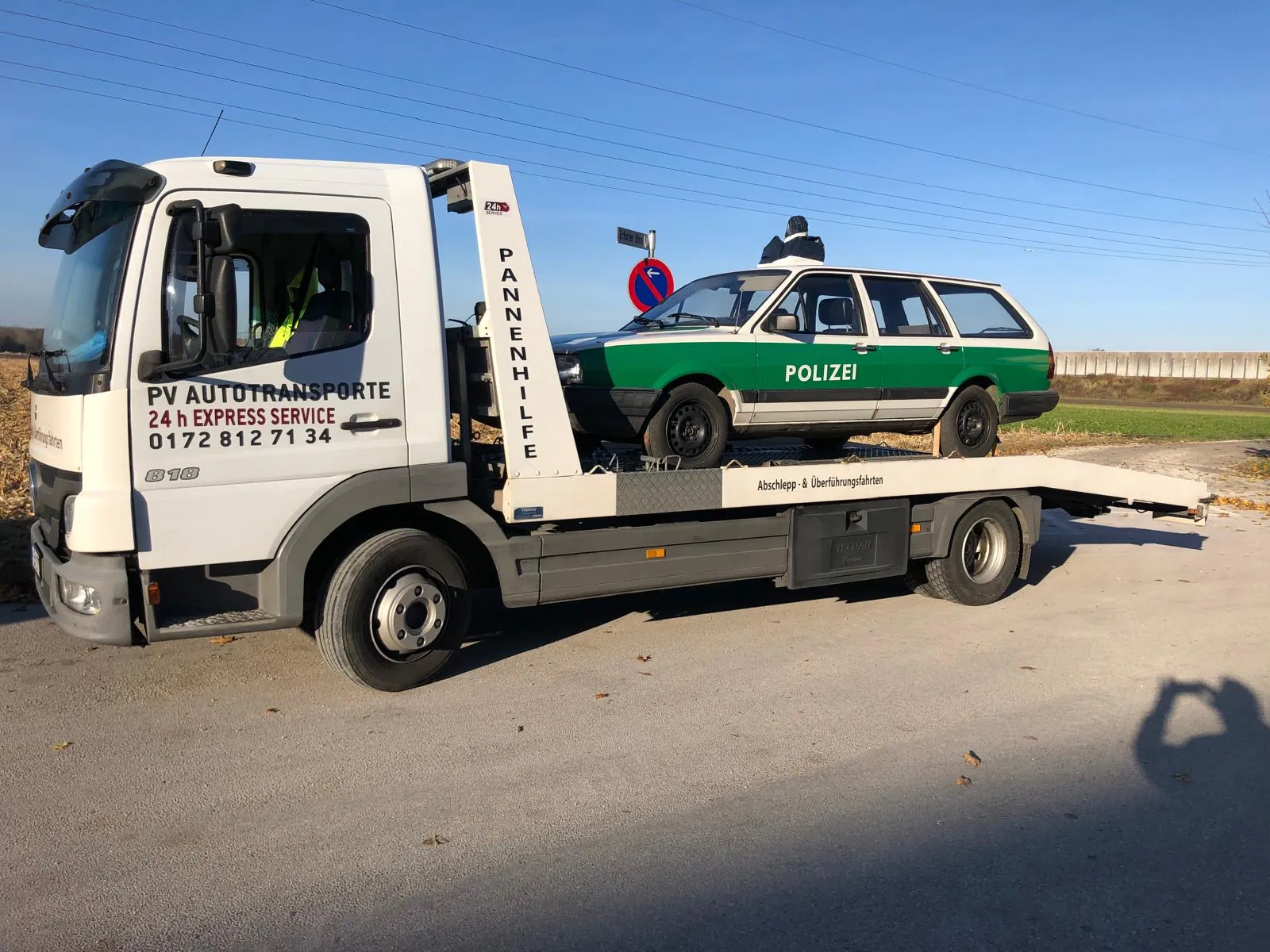 Historisches Polizeifahrzeug auf einem PV Transportfahrzeug