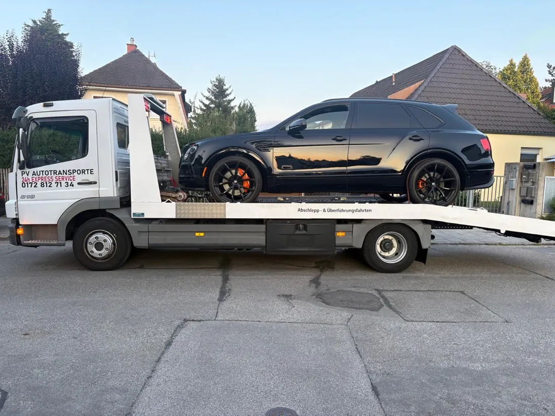 Black Bentley Bentayga on a white PV transport truck