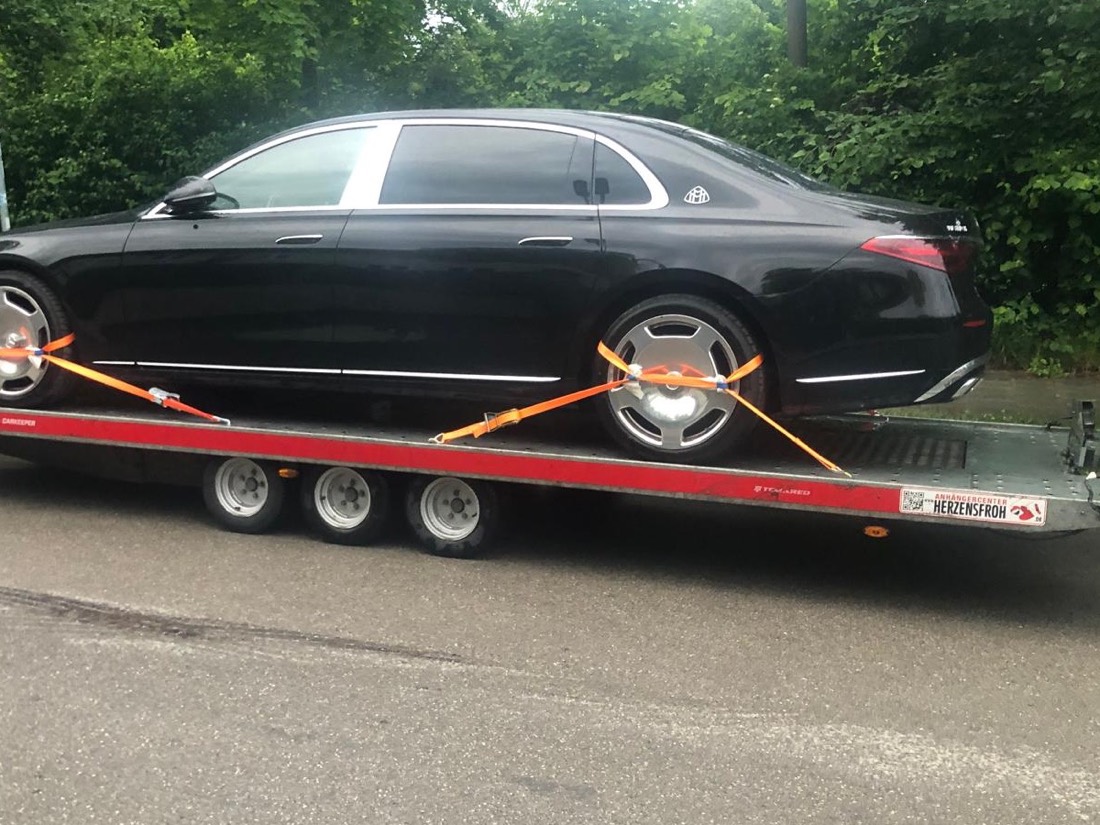 Schwarze Mercedes-Maybach Limousine auf einem offenen Fahrzeuganhänger
