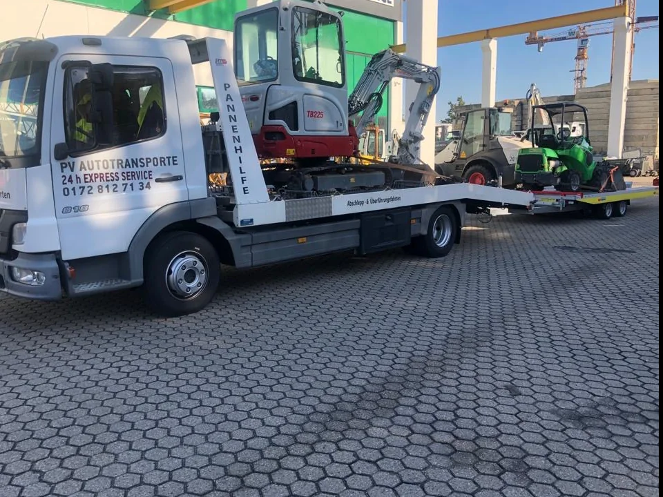 Kompaktbagger und Kompaktlader auf einem PV Transportfahrzeug mit Anhänger